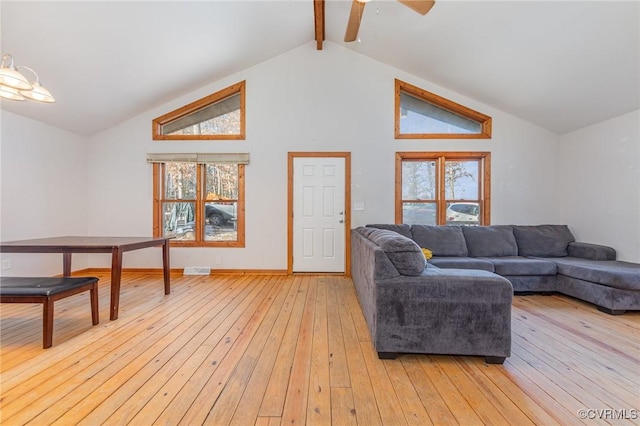 living room with vaulted ceiling with beams and light hardwood / wood-style flooring