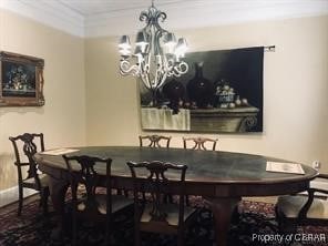 dining room featuring ornamental molding and a notable chandelier