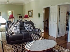 living room featuring dark wood-type flooring and ceiling fan