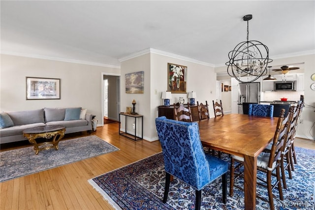 dining area with an inviting chandelier, wood-type flooring, and ornamental molding