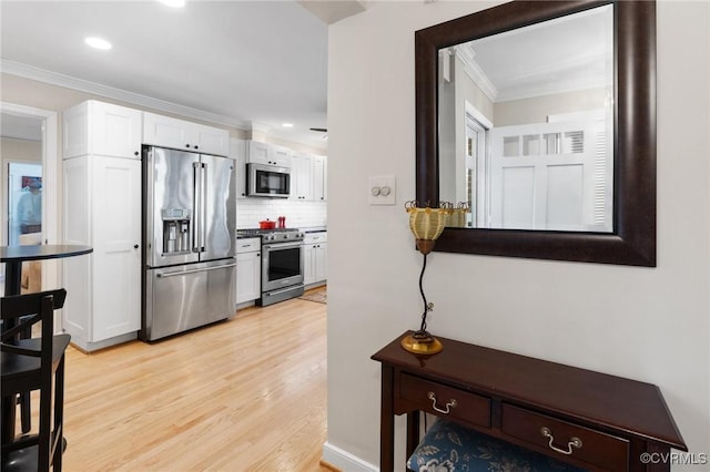 kitchen with white cabinets, crown molding, decorative backsplash, and high quality appliances