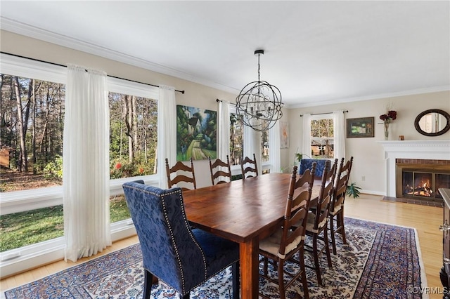 dining space featuring crown molding, a notable chandelier, and light hardwood / wood-style floors