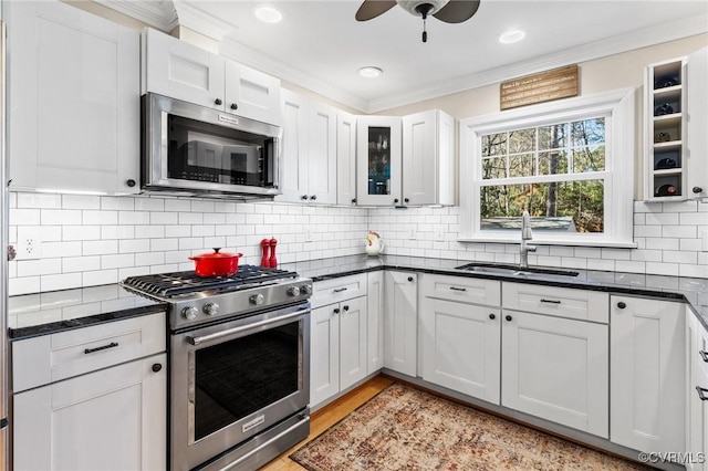 kitchen featuring sink, tasteful backsplash, ornamental molding, stainless steel appliances, and white cabinets