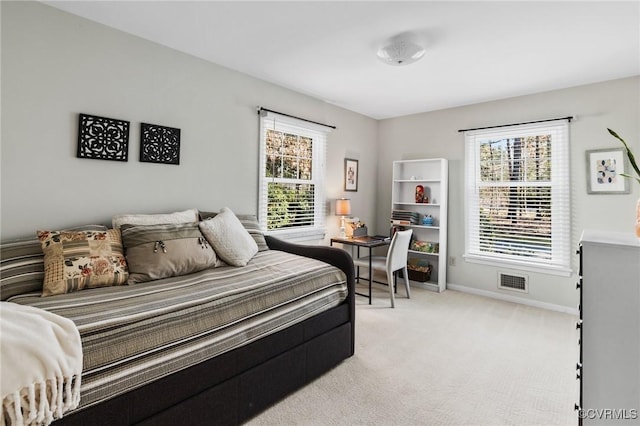 bedroom with multiple windows and light colored carpet