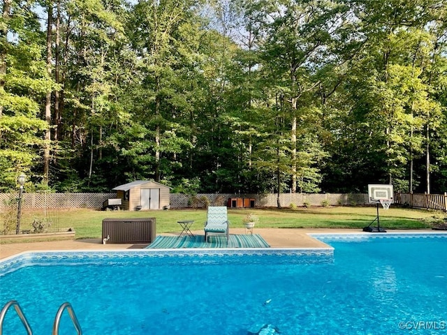 view of swimming pool featuring a lawn and a storage unit