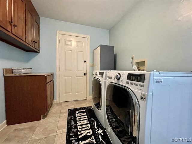 laundry area with cabinets, washing machine and clothes dryer, and light tile patterned floors