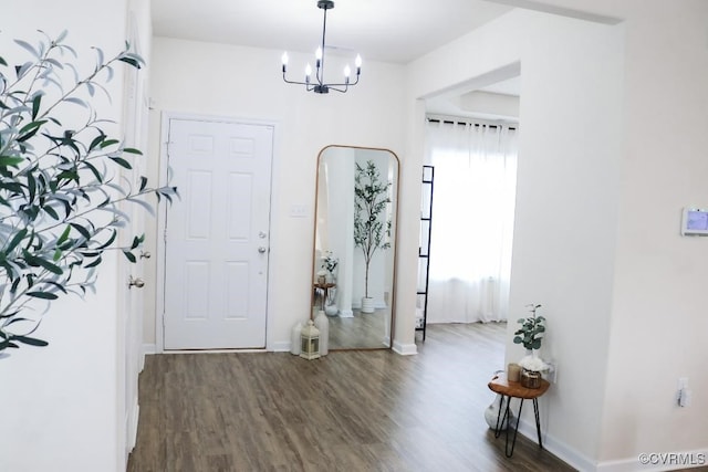 foyer entrance featuring dark hardwood / wood-style floors and a notable chandelier