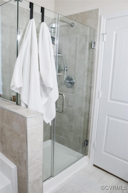 bathroom featuring tile patterned floors and a shower with door