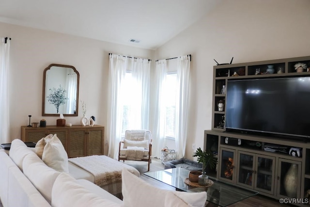 living room with a wealth of natural light, vaulted ceiling, and wood-type flooring