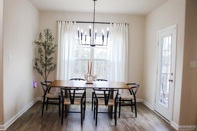 dining room featuring dark wood-type flooring and an inviting chandelier