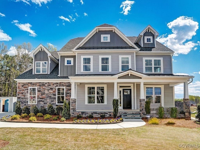 craftsman house featuring covered porch and a front yard