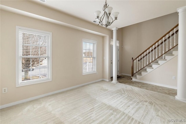 foyer with a notable chandelier, carpet floors, and decorative columns