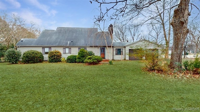 back of property featuring a yard and a garage