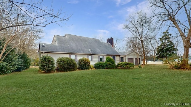 rear view of house with a garage and a yard