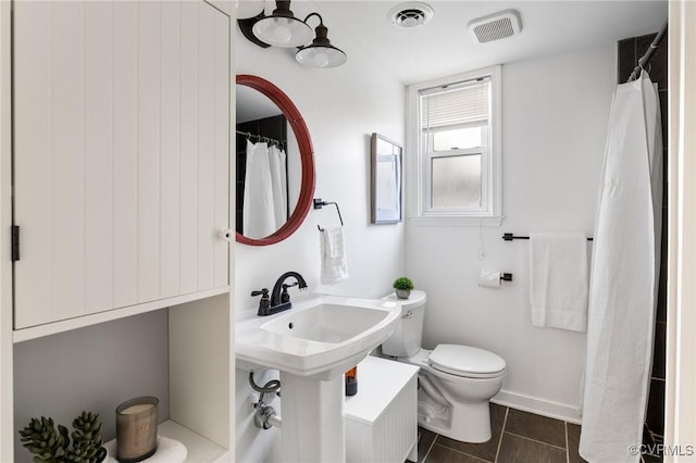 bathroom featuring toilet and tile patterned flooring