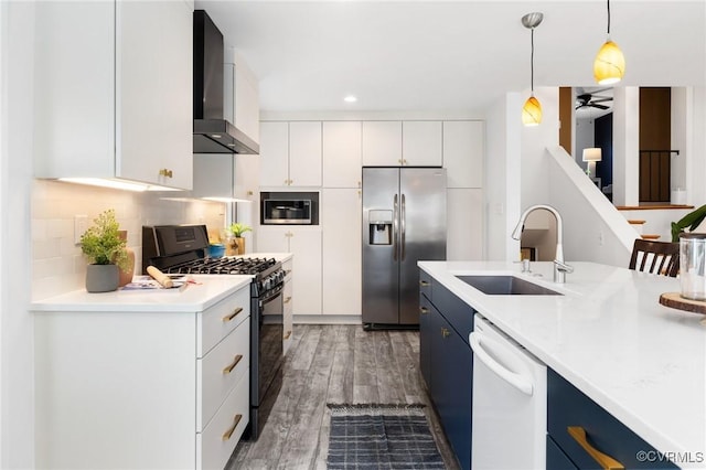 kitchen with wall chimney exhaust hood, stainless steel appliances, blue cabinets, and white cabinets