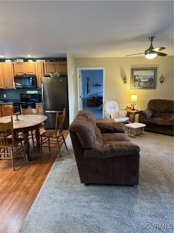 living room featuring wood-type flooring and ceiling fan