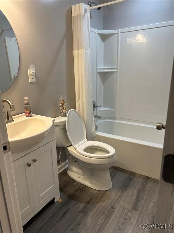 full bathroom featuring hardwood / wood-style flooring, toilet, vanity, and shower / bath combo with shower curtain