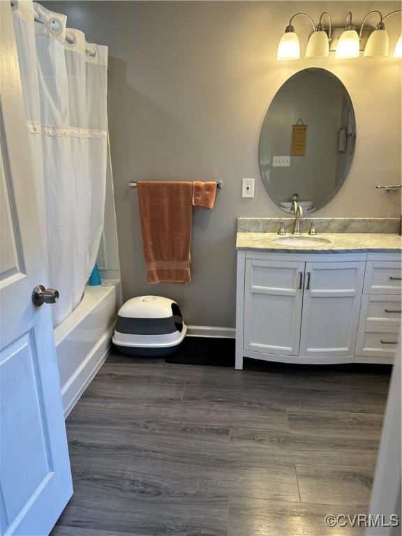 bathroom featuring vanity, wood-type flooring, and shower / bath combo