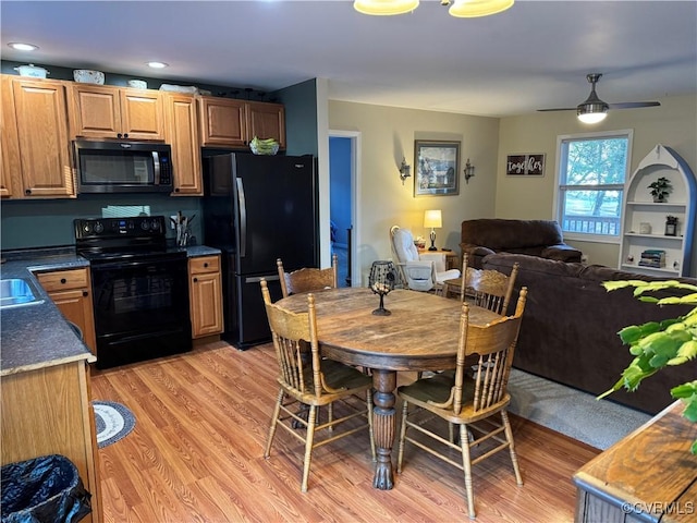 kitchen featuring ceiling fan, light hardwood / wood-style floors, and black appliances