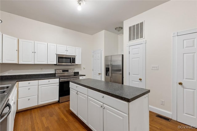 kitchen featuring a kitchen island, light hardwood / wood-style floors, white cabinets, and appliances with stainless steel finishes