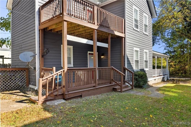 rear view of house featuring a deck and a lawn