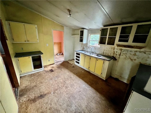 kitchen featuring lofted ceiling, sink, and beverage cooler