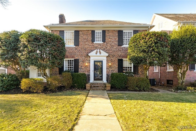 view of front of house with a front lawn and central air condition unit