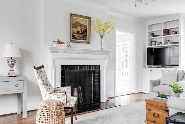 living room featuring crown molding, hardwood / wood-style floors, and built in shelves