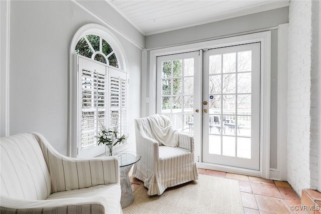 sitting room with crown molding, light tile patterned floors, and french doors