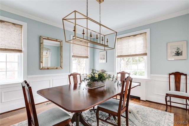 dining area with hardwood / wood-style flooring and ornamental molding