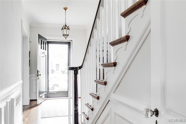 foyer with wood-type flooring and crown molding