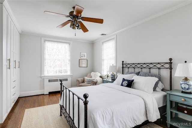 bedroom with dark wood-type flooring, radiator heating unit, ornamental molding, and ceiling fan