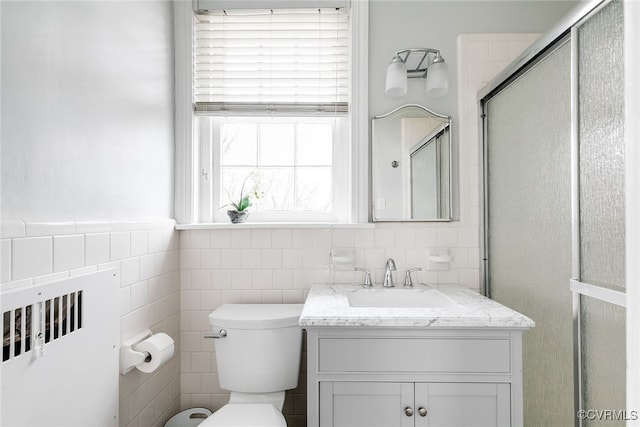 bathroom with an enclosed shower, vanity, a wealth of natural light, and toilet