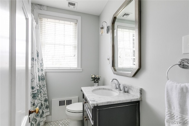 bathroom featuring vanity, a wealth of natural light, and toilet