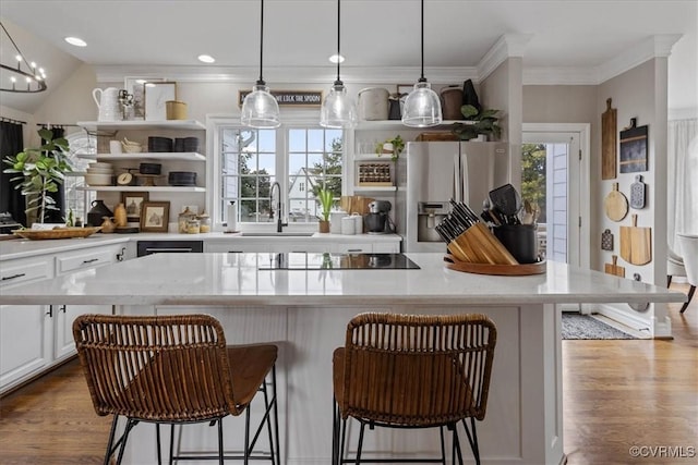 kitchen with white cabinetry, a breakfast bar, sink, and stainless steel fridge with ice dispenser