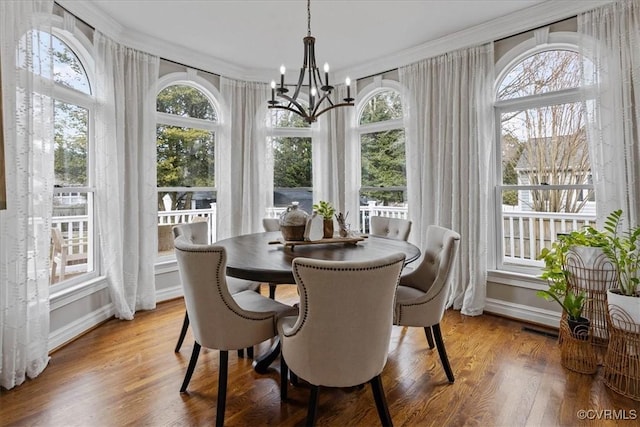 sunroom / solarium featuring a chandelier