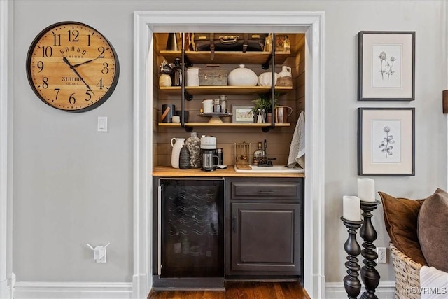 bar with sink, dark wood-type flooring, and beverage cooler