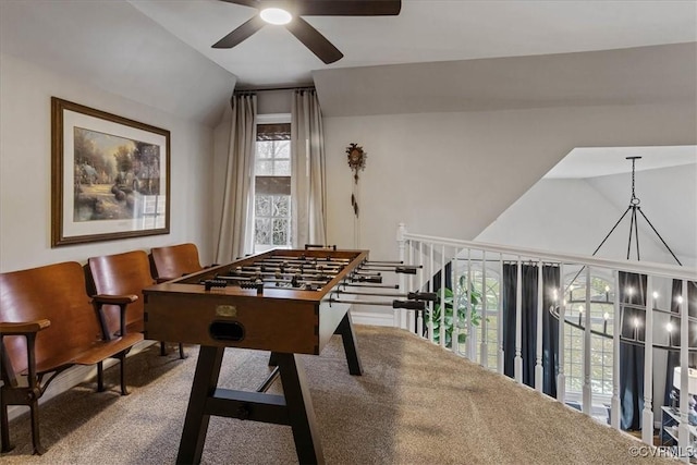 rec room with lofted ceiling, carpet flooring, and ceiling fan with notable chandelier