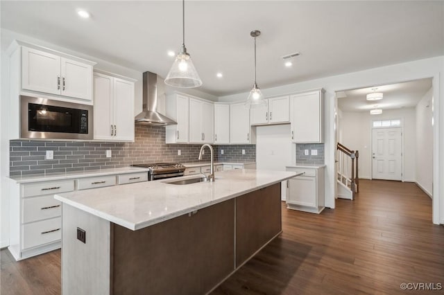 kitchen with white cabinetry, wall chimney exhaust hood, sink, and black microwave