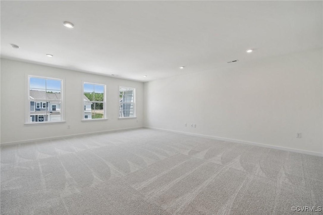 spare room with light colored carpet and plenty of natural light