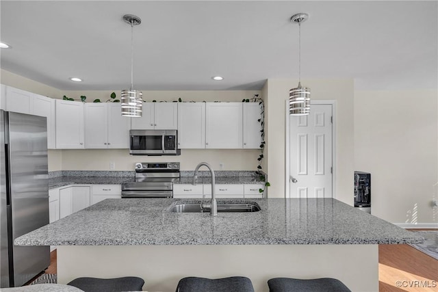 kitchen with white cabinetry, sink, hanging light fixtures, and appliances with stainless steel finishes