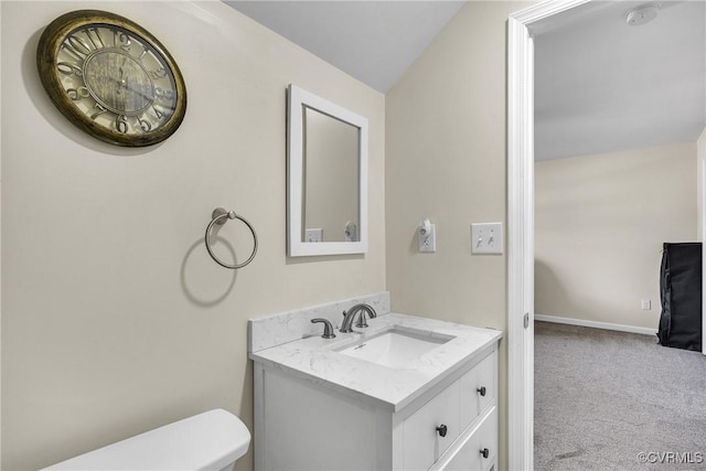 bathroom with vanity, lofted ceiling, and toilet