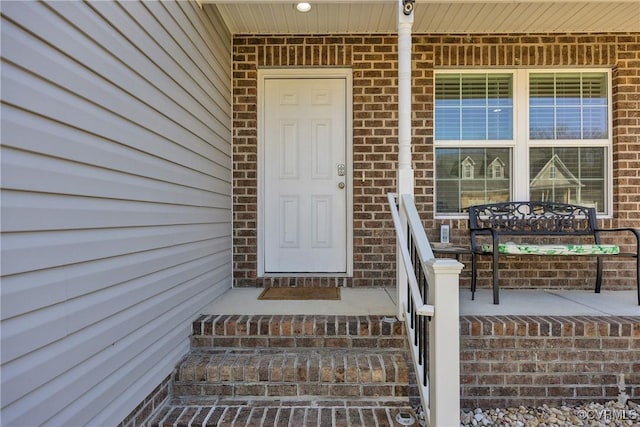 view of exterior entry featuring covered porch