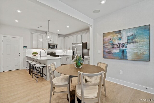 dining space featuring sink and light hardwood / wood-style flooring