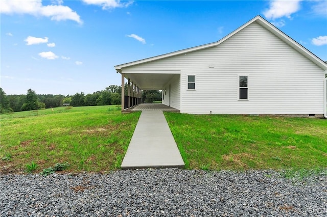 view of side of home with a carport and a yard