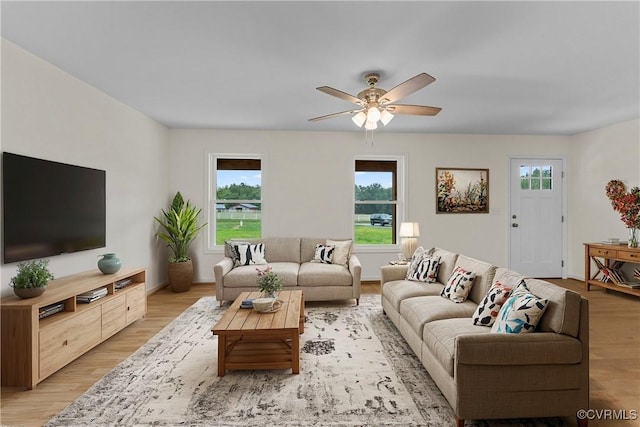 living room with light hardwood / wood-style flooring and ceiling fan