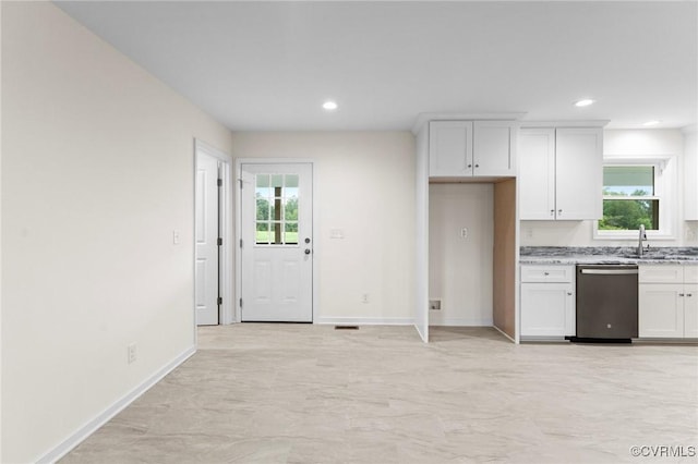 kitchen with light stone counters, sink, stainless steel dishwasher, and white cabinets