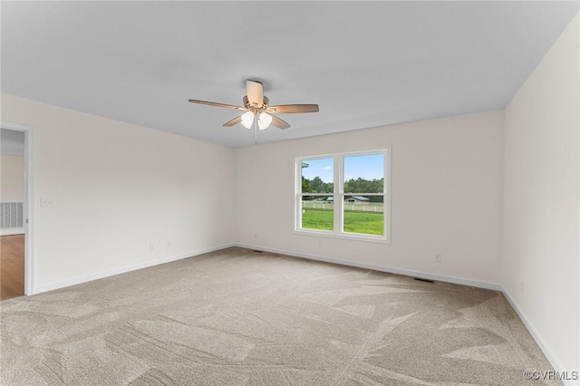 carpeted spare room with ceiling fan