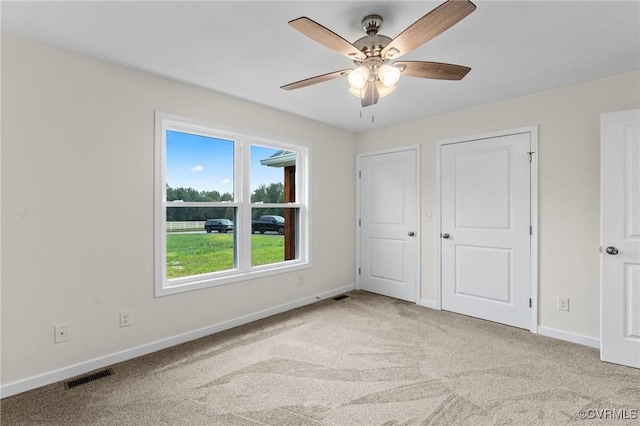 unfurnished bedroom featuring ceiling fan and light colored carpet